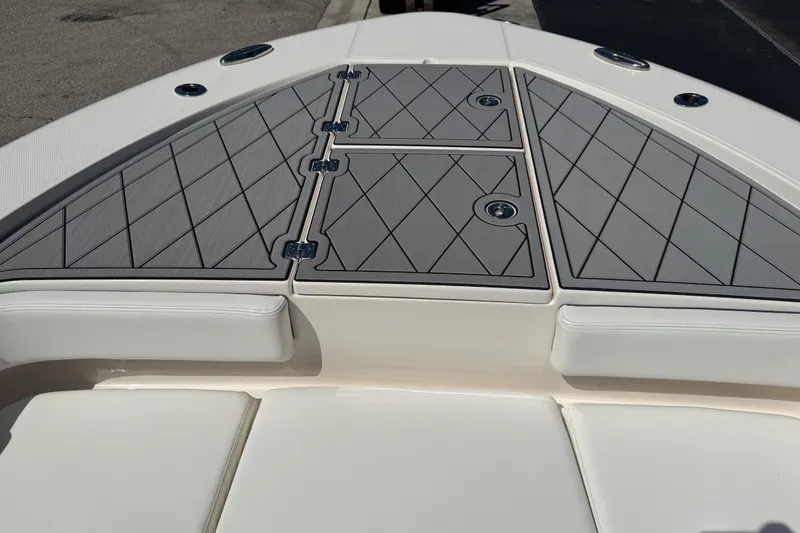 Slide: The Image of 2022 Robalo 266 Cayman boat deck with cushioned seating and storage hatches. - 75