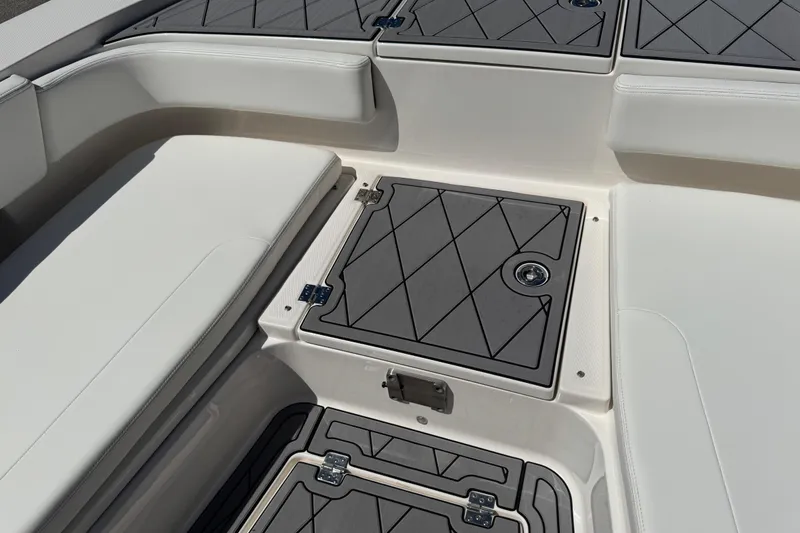 Slide: The Image of 2022 Robalo 266 Cayman boat interior with cushioned seating and storage compartments. - 76
