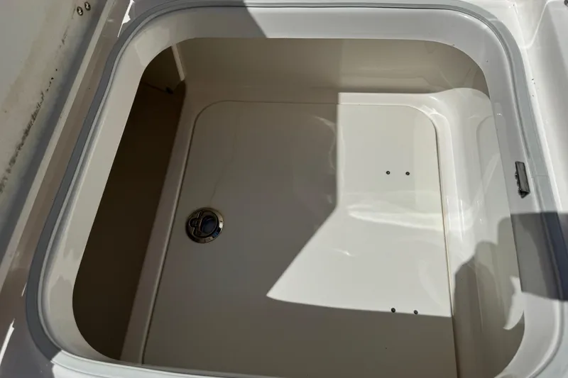 Slide: The Image of Storage compartment of 2022 Robalo 266 Cayman boat, featuring a clean, white interior. - 77
