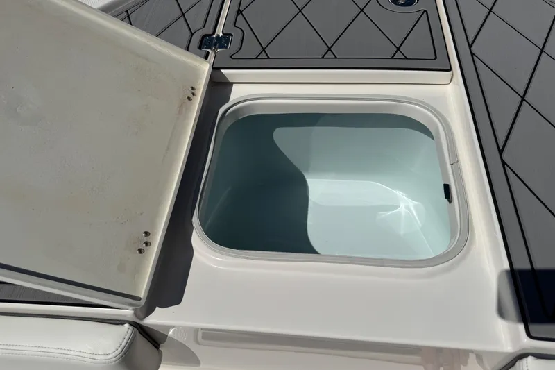 Slide: The Image of Open storage compartment on 2022 Robalo 266 Cayman boat, featuring a clean interior. - 79