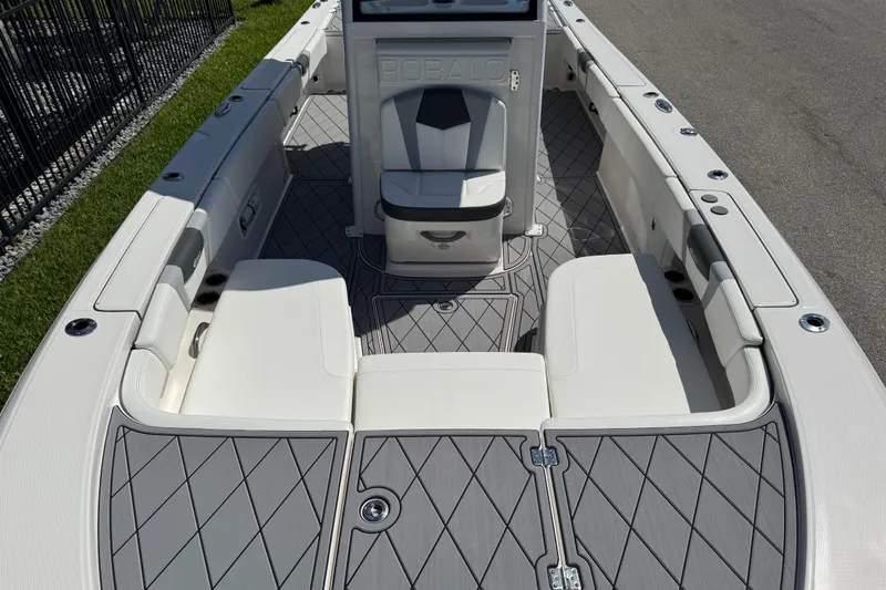 Slide: The Image of 2022 Robalo 266 Cayman boat interior with cushioned seating and diamond-patterned flooring. - 84