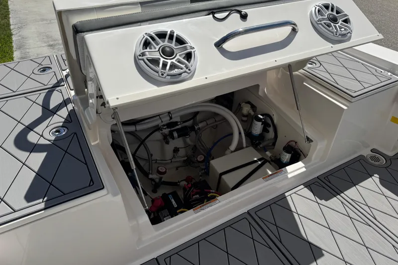 Slide: The Image of 2022 Robalo 266 Cayman boat interior showing storage compartment and speaker system. - 98