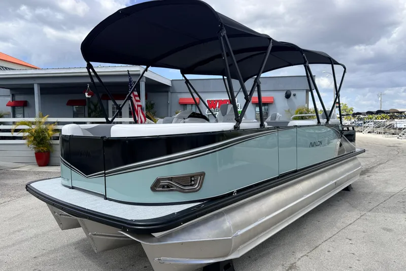 The Image of 2026 Avalon 2385 LSZ Rear Fish Tri Toon boat with canopy, parked outdoors. - 1