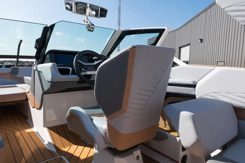 Slide: The Image of 2026 MasterCraft X24 boat on trailer, parked outside a building under clear blue sky. - 11