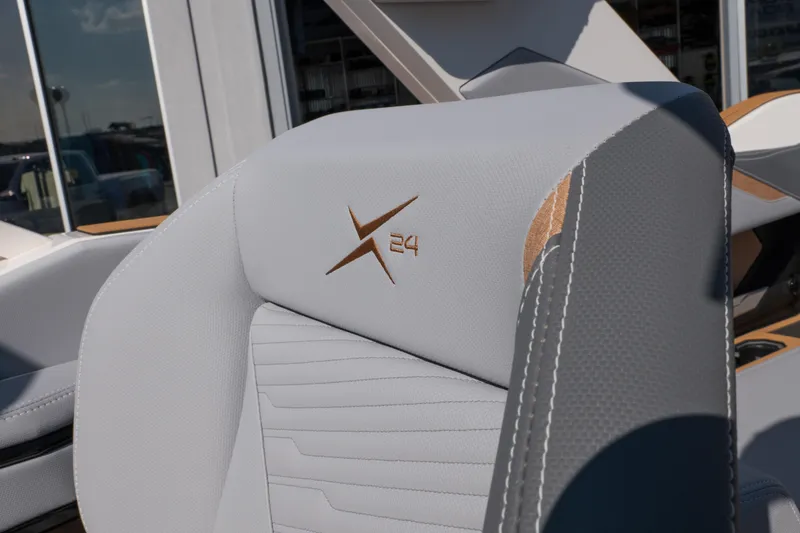 Slide: The Image of 2026 MasterCraft X24 boat interior with sleek seating and storage compartment. - 18