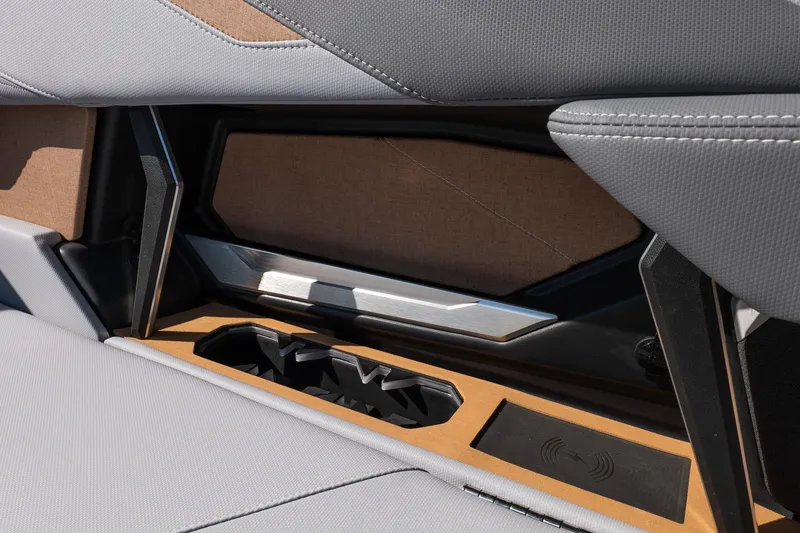 Slide: The Image of Interior detail of 2026 MasterCraft X24 boat with cup holders and wireless charging pad. - 22