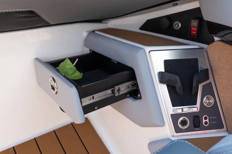 Slide: The Image of 2026 MasterCraft X24 boat interior with open storage compartment and control panel. - 32