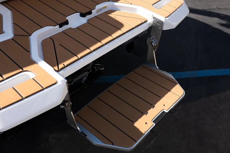 Slide: The Image of 2026 MasterCraft X24 boat with gold accents on a trailer, parked outdoors. - 7