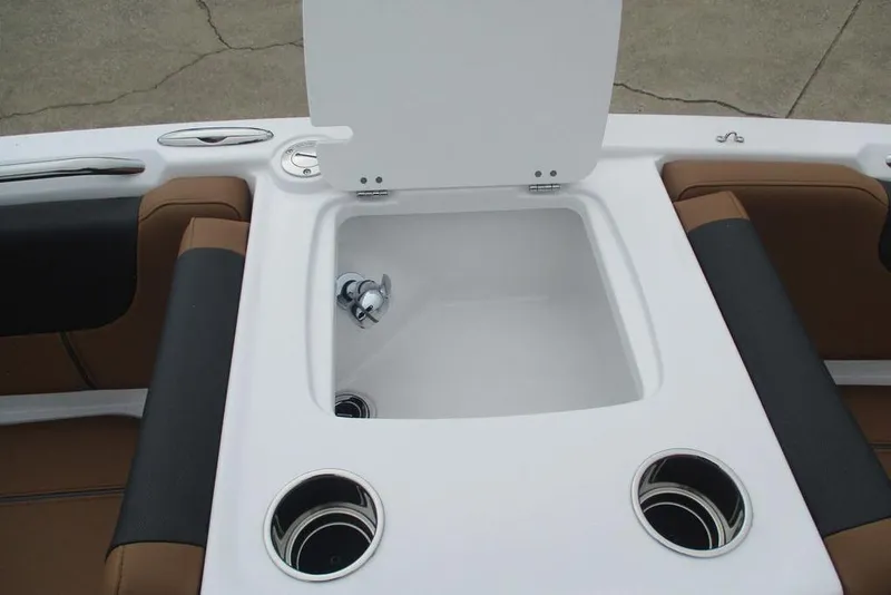 Slide: The Image of 2026 Tahoe 2150 boat interior with open storage compartment and cup holders. - 13