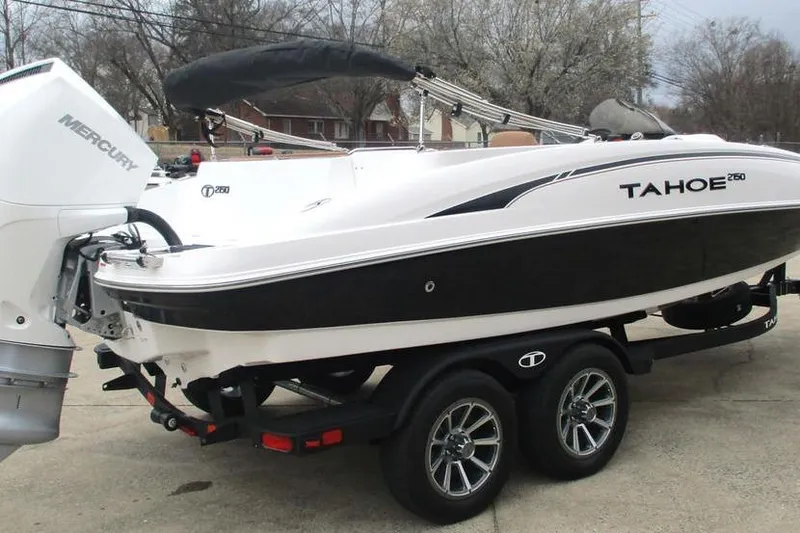 Slide: The Image of 2026 Tahoe 2150 boat on trailer with Mercury engine, parked outdoors. - 2