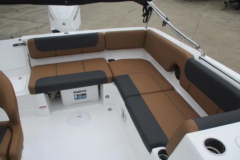 Slide: The Image of 2026 Tahoe 2150 boat interior with brown and black seating, featuring an Igloo cooler. - 7