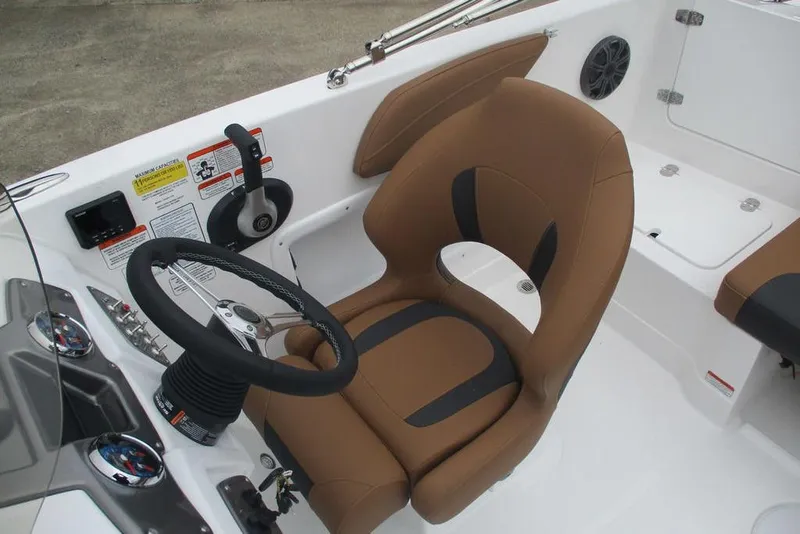 Slide: The Image of 2026 Tahoe 2150 boat interior with brown captain's chair and steering wheel. - 9