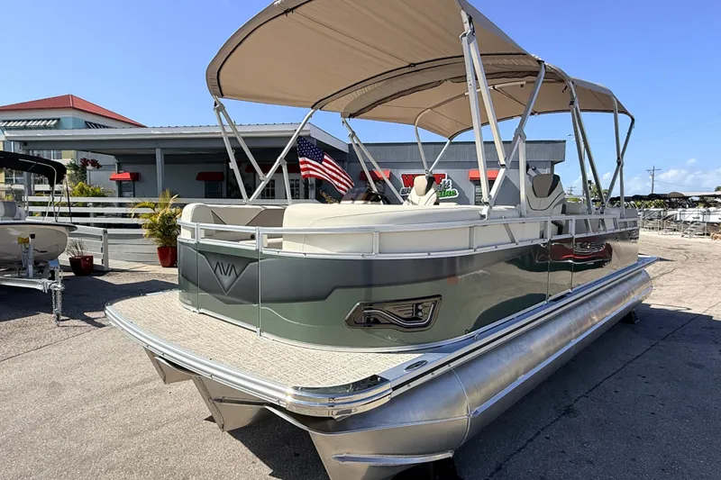The Image of 2026 Avalon 2385 Venture 85 Quad Lounger Tri Toon boat with canopy and American flag. - 1