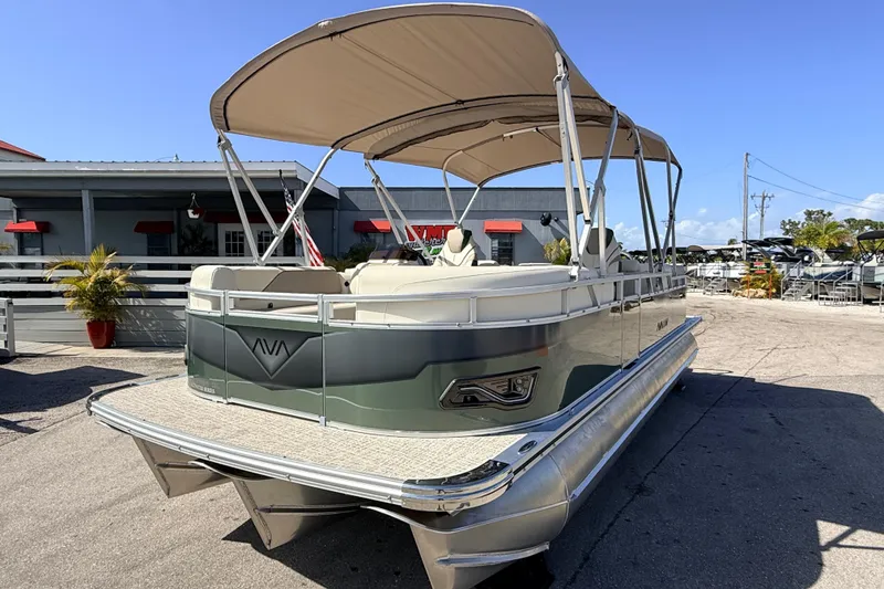 Slide: The Image of 2026 Avalon 2385 Venture 85 Quad Lounger Tri Toon boat with canopy, docked outdoors. - 3
