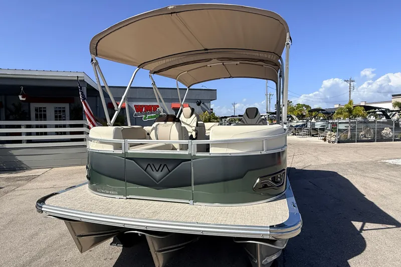 Slide: The Image of 2026 Avalon 2385 Venture 85 Quad Lounger Tri Toon boat with canopy, parked outdoors. - 4