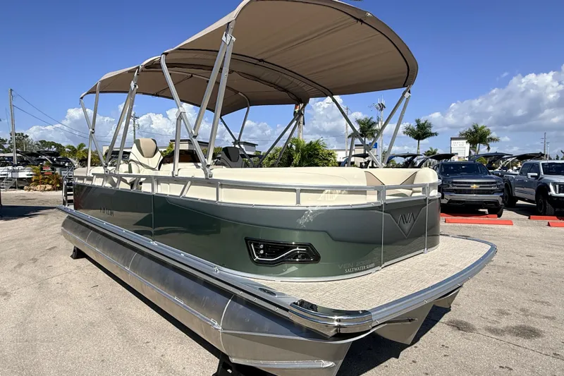 Slide: The Image of 2026 Avalon 2385 Venture 85 Quad Lounger Tri Toon boat with canopy, parked outdoors. - 6