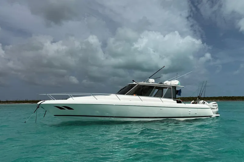 The Image of 2009 Intrepid 430 Sport Yacht on turquoise water under cloudy sky. - 0