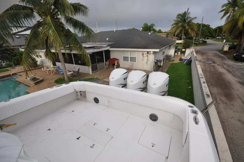 Slide: The Image of 2009 Intrepid 430 Sport Yacht docked near a house with palm trees and a pool. - 10