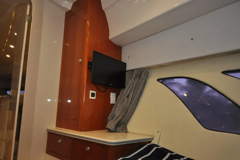 Slide: The Image of Interior of 2009 Intrepid 430 Sport Yacht with TV, wooden cabinetry, and window. - 15