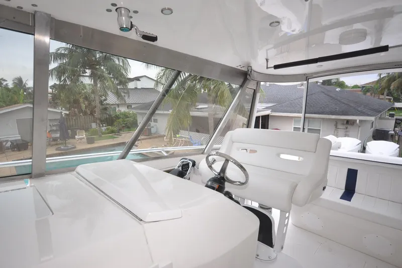 Slide: The Image of Interior view of 2009 Intrepid 430 Sport Yacht helm with white seating and steering wheel. - 18