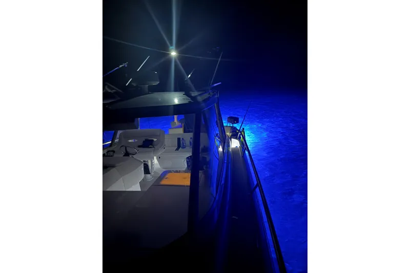 Slide: The Image of 2009 Intrepid 430 Sport Yacht illuminated at night with blue underwater lights. - 31