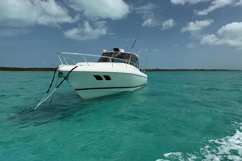Slide: The Image of 2009 Intrepid 430 Sport Yacht anchored in clear turquoise waters under a partly cloudy sky. - 33