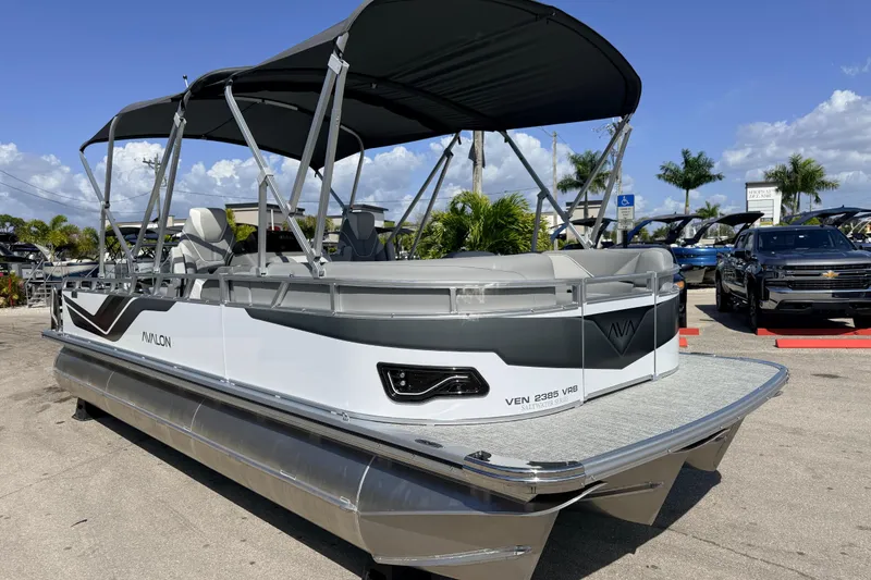 Slide: The Image of 2026 Avalon 2385 Venture 85 VRB Tri Toon boat with canopy, parked outdoors. - 5