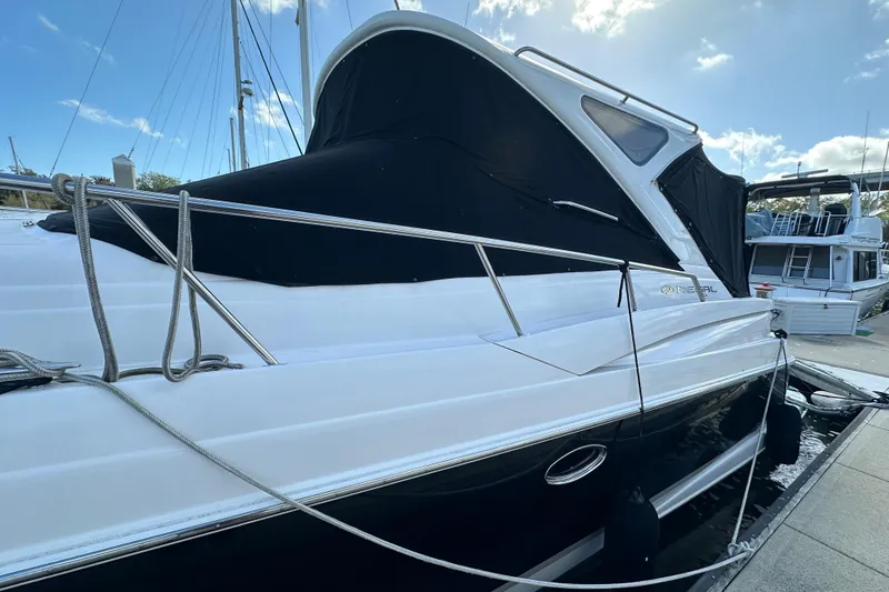 Slide: The Image of 2008 Regal Commodore 4060 yacht docked, featuring sleek design and black canvas cover. - 10