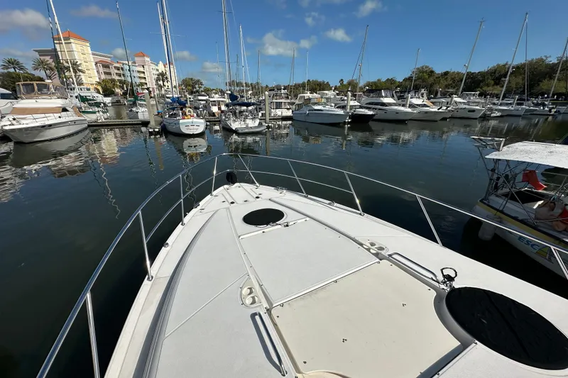 Slide: The Image of Bow view of 2008 Regal Commodore 4060 yacht docked in a marina with other boats. - 13