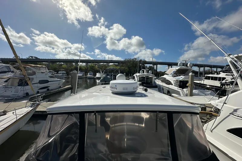 Slide: The Image of 2008 Regal Commodore 4060 yacht docked at marina under blue sky. - 17