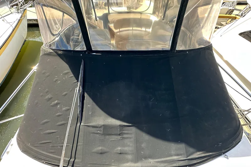 Slide: The Image of 2008 Regal Commodore 4060 boat with black cover and clear enclosure in marina. - 19