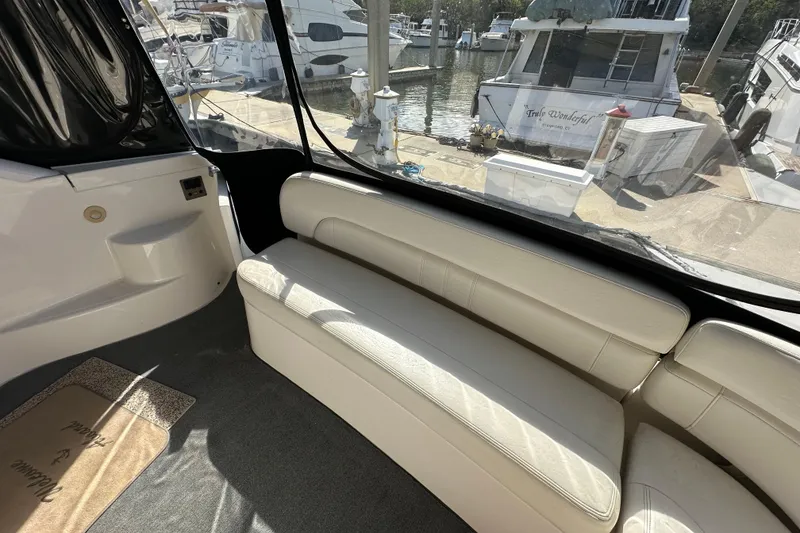 Slide: The Image of Interior of 2008 Regal Commodore 4060 yacht with white seating and marina view. - 24
