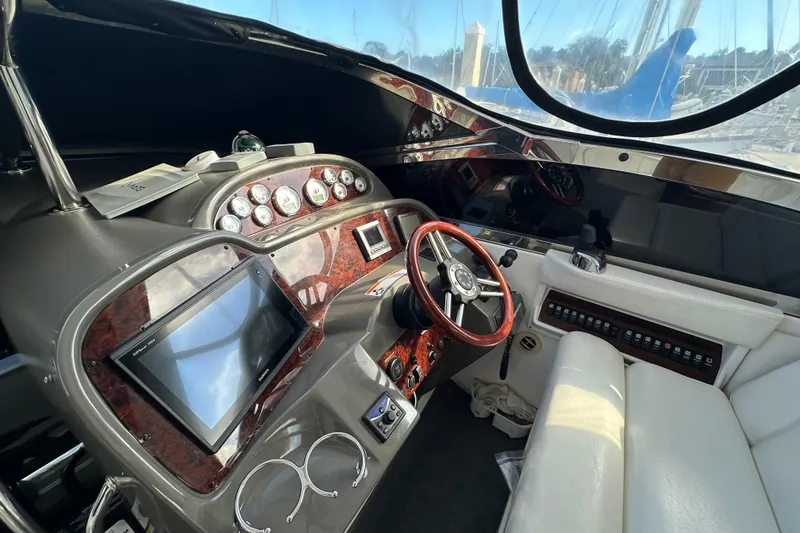 Slide: The Image of Interior of a 2008 Regal Commodore 4060 yacht cockpit with steering wheel and control panel. - 30