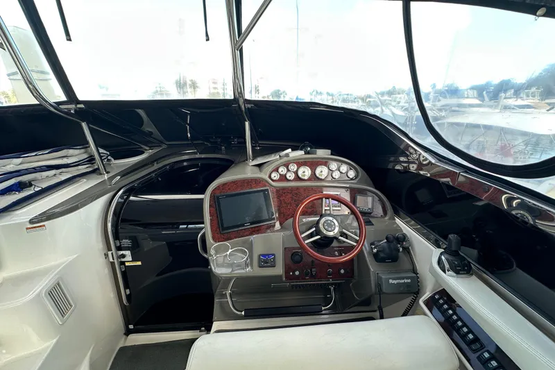 Slide: The Image of 2008 Regal Commodore 4060 yacht cockpit with steering wheel, navigation controls, and dashboard instruments. - 38