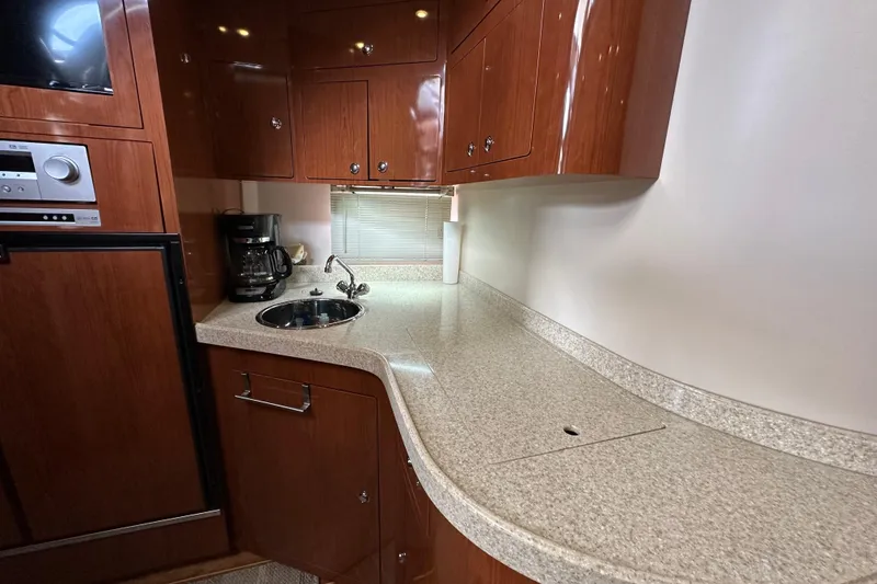 Slide: The Image of 2008 Regal Commodore 4060 yacht kitchen with wood cabinets and modern appliances. - 48