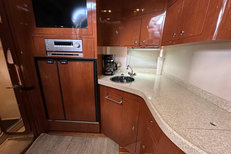 Slide: The Image of 2008 Regal Commodore 4060 yacht kitchen with wood cabinets, sink, and appliances. - 49