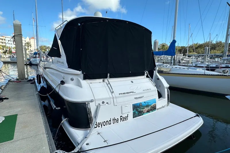 Slide: The Image of 2008 Regal Commodore 4060 yacht docked at marina, featuring sleek design and covered deck. - 5