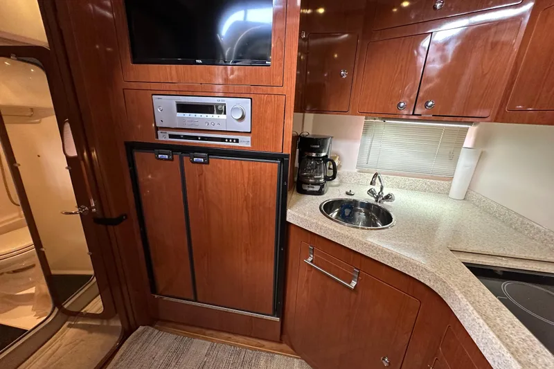 Slide: The Image of 2008 Regal Commodore 4060 yacht kitchen with wood cabinets, sink, and appliances. - 51