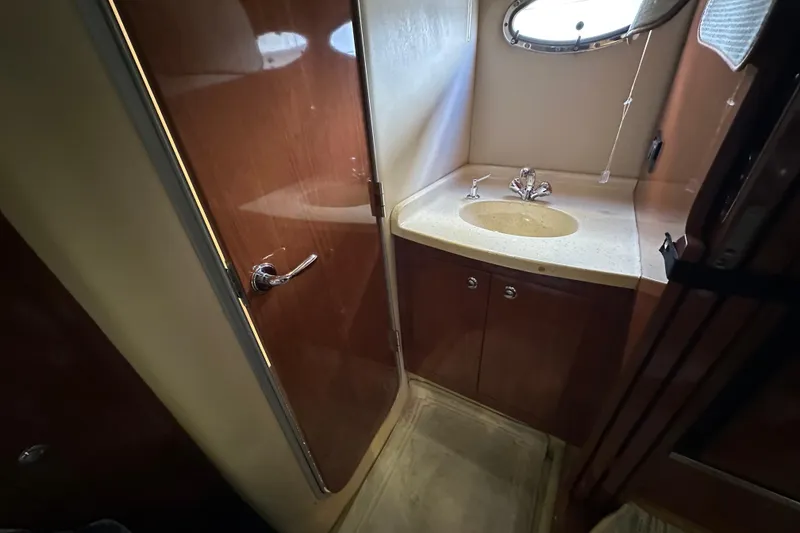 Slide: The Image of 2008 Regal Commodore 4060 yacht bathroom with sink and wooden cabinetry. - 57