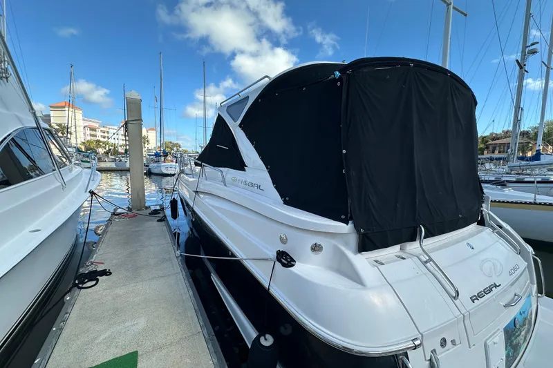 Slide: The Image of 2008 Regal Commodore 4060 yacht docked at marina under clear blue sky. - 6