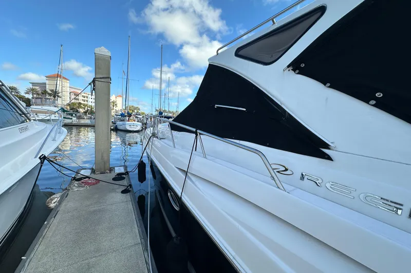 Slide: The Image of 2008 Regal Commodore 4060 yacht docked at marina under blue sky. - 7