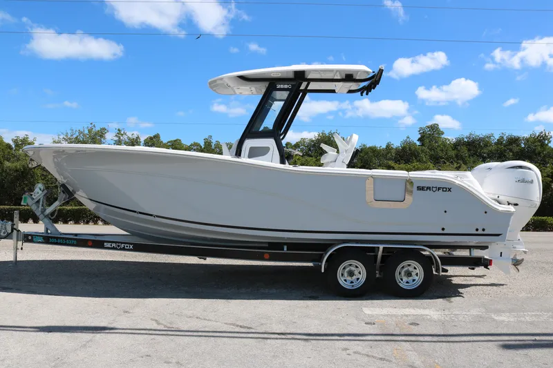 The Image of 2026 Sea Fox 268 Commander boat on trailer under clear blue sky. - 1