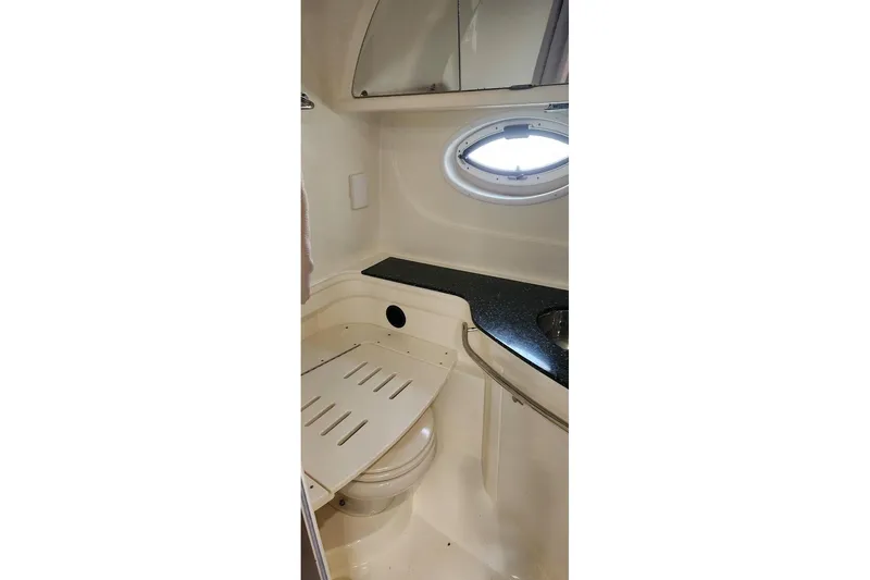Slide: The Image of 2015 Monterey 335 Sport Yacht bathroom with porthole, sink, and toilet. - 10