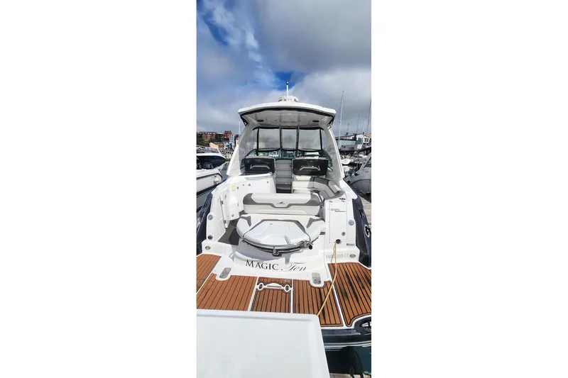 Slide: The Image of 2015 Monterey 335 Sport Yacht with spacious deck and seating, docked under cloudy skies. - 5
