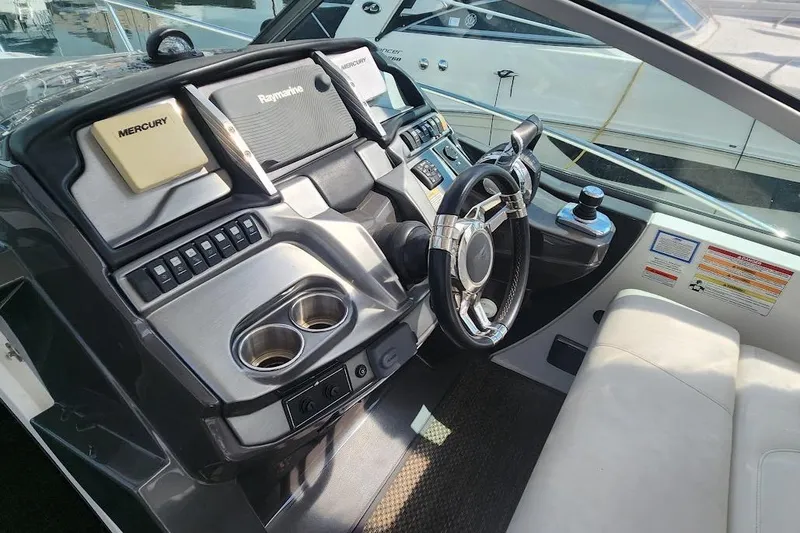 Slide: The Image of 2015 Monterey 335 Sport Yacht helm with steering wheel and navigation controls. - 6