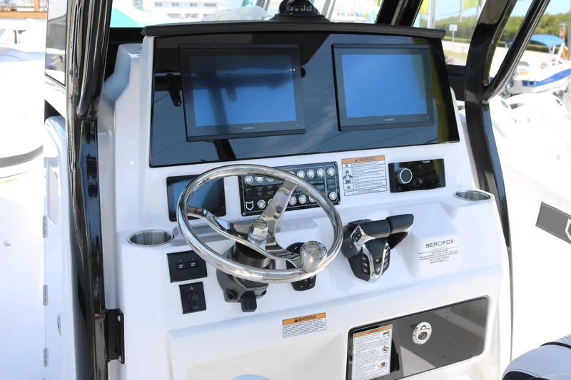 Slide: The Image of 2026 Sea Fox 288 Commander boat dashboard with dual screens and steering wheel. - 11