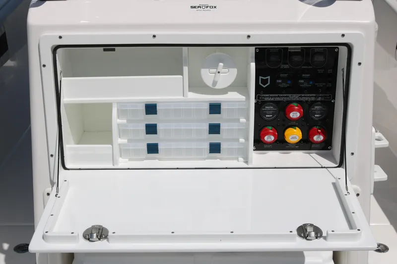 Slide: The Image of 2026 Sea Fox 288 Commander storage compartment with control panel and organized storage bins. - 12
