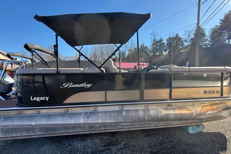 Slide: The Image of 2023 Bentley Pontoons 220 Navigator boat with canopy, parked outdoors on a sunny day. - 1