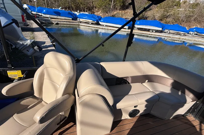Slide: The Image of 2023 Bentley Pontoons 220 Navigator interior with beige seating by a dock. - 3