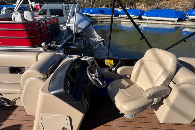 Slide: The Image of 2023 Bentley Pontoons 220 Navigator interior with beige seating and steering console. - 9